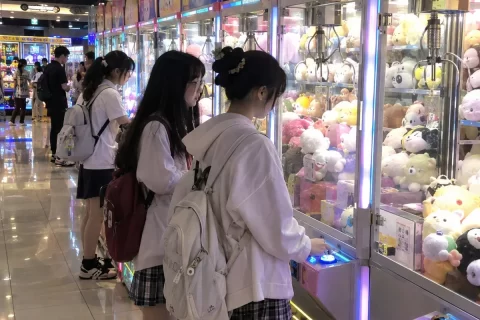 新手玩家在教练机前学习甩爪技巧
